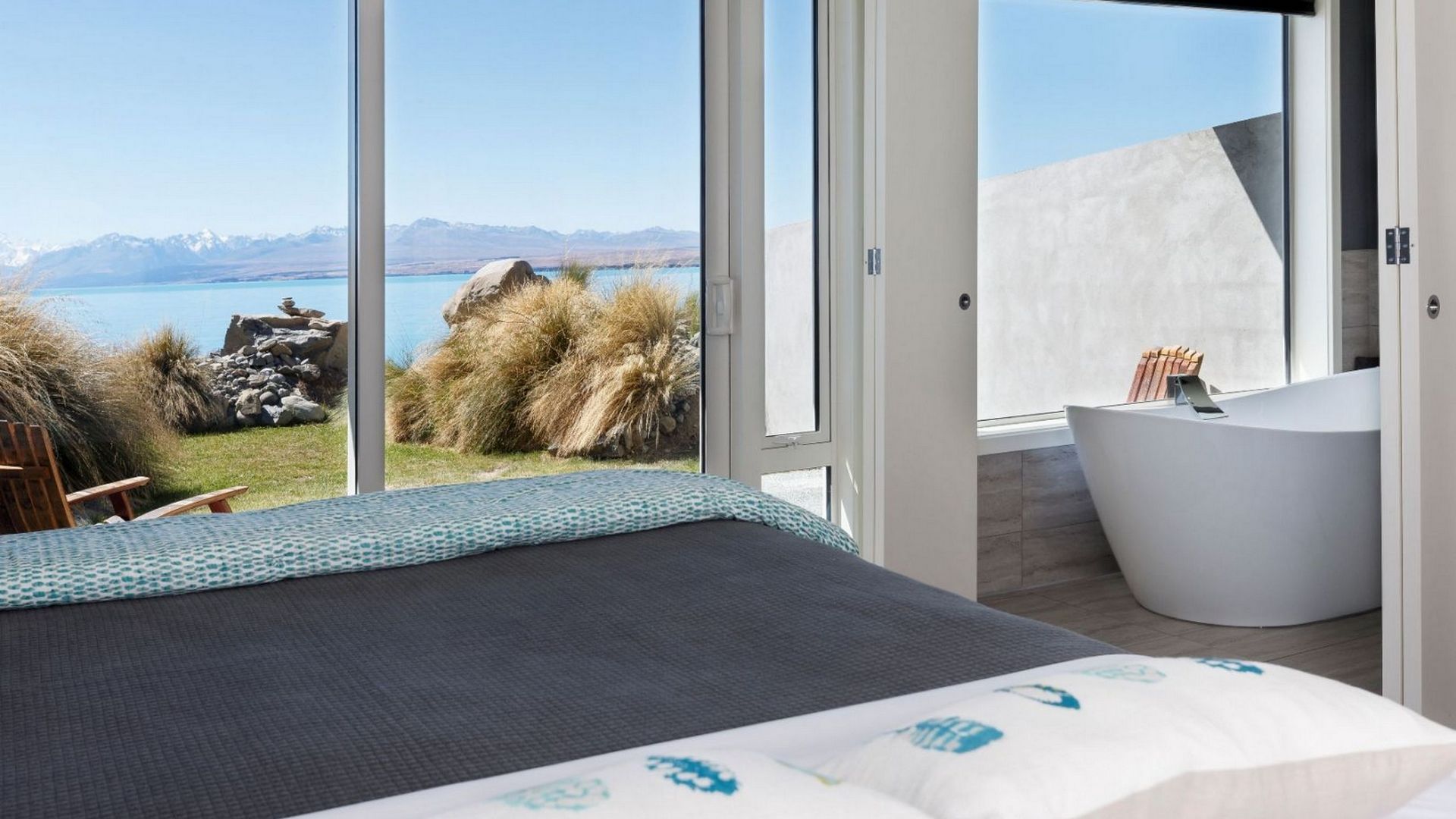 Rooms feature a luxurious bathtub nestled beside a window, which enables guests to enjoy the view of the lake and mountains while soaking