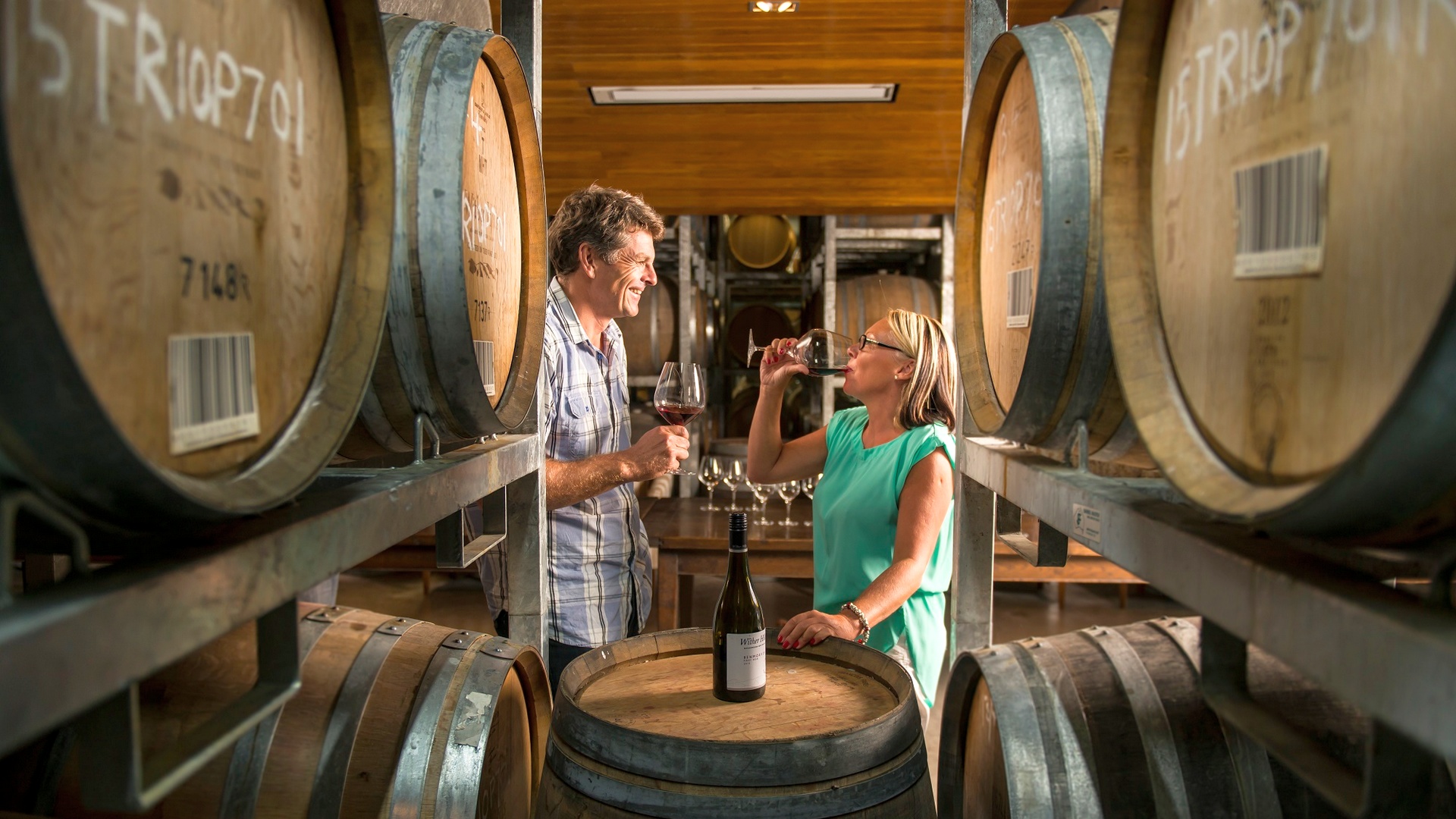 Guest sampling wine walking through a vineyard on a Marlborough Tour Company tour