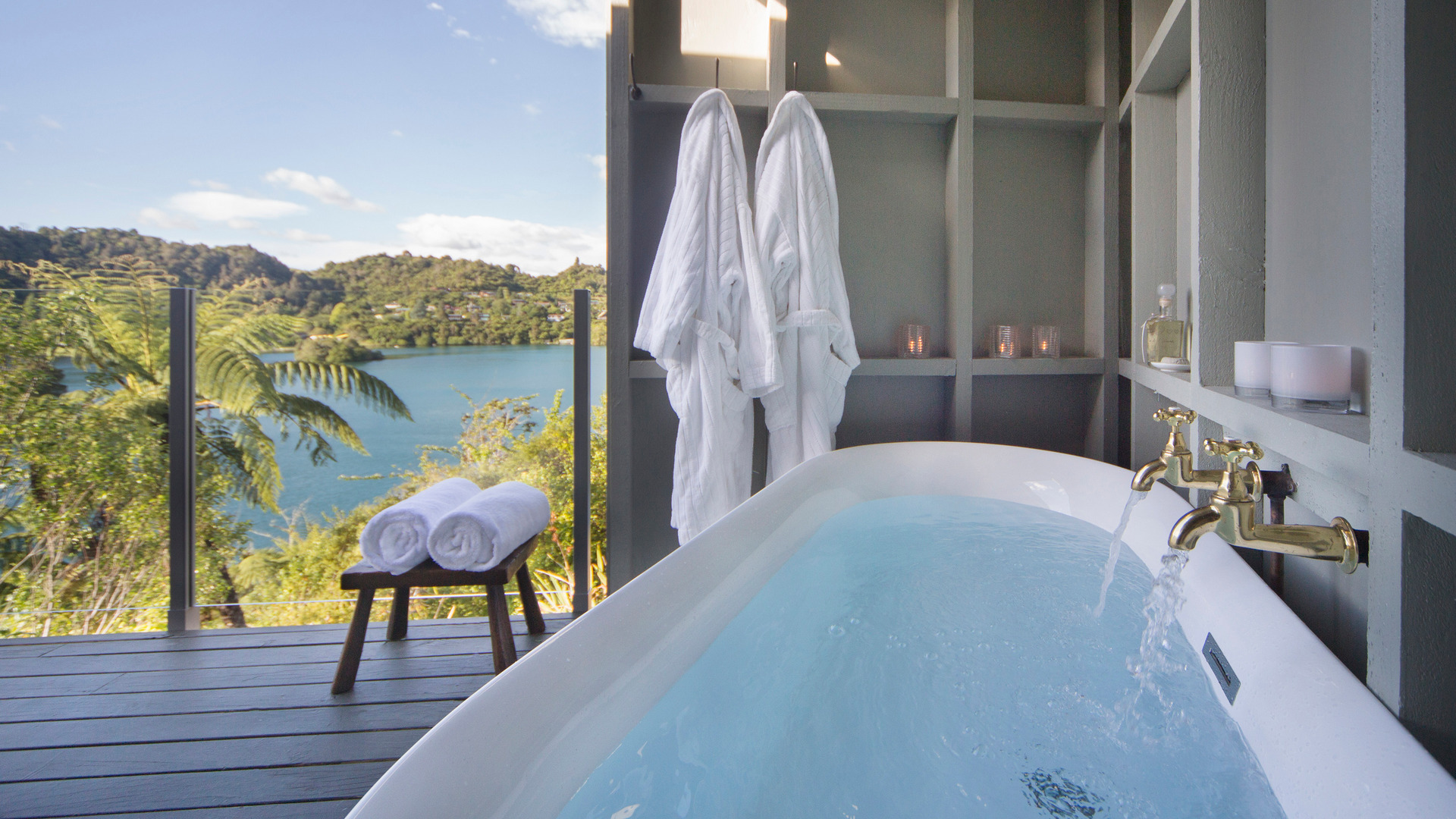 Enjos breathtaking views over Lake Tarawera with a lush natural bush and volcanic landscape backdrop